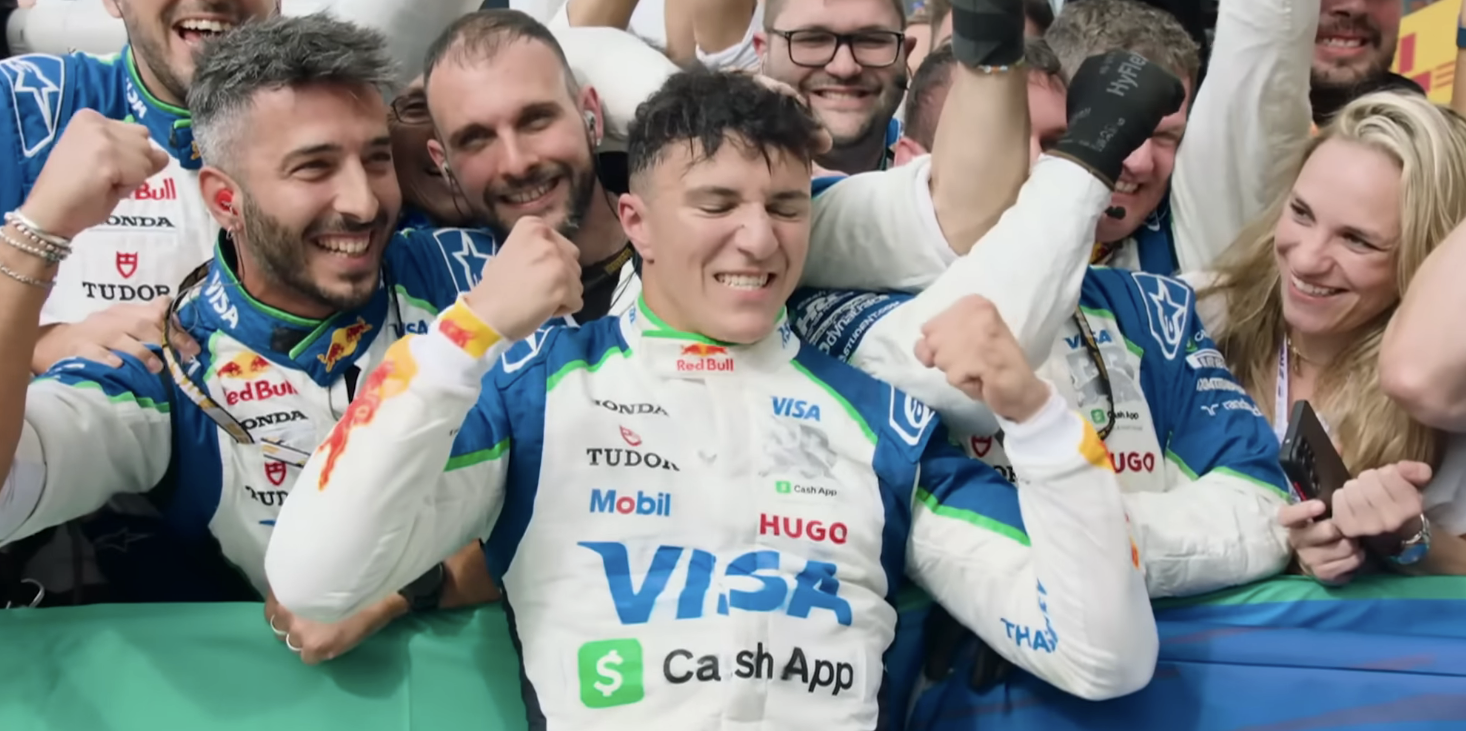 Isack Hadjar celebrating his first podium with Racing Bulls in 2025 at the Dutch Grand Prix. Members of the Racing Bulls team are in the background.